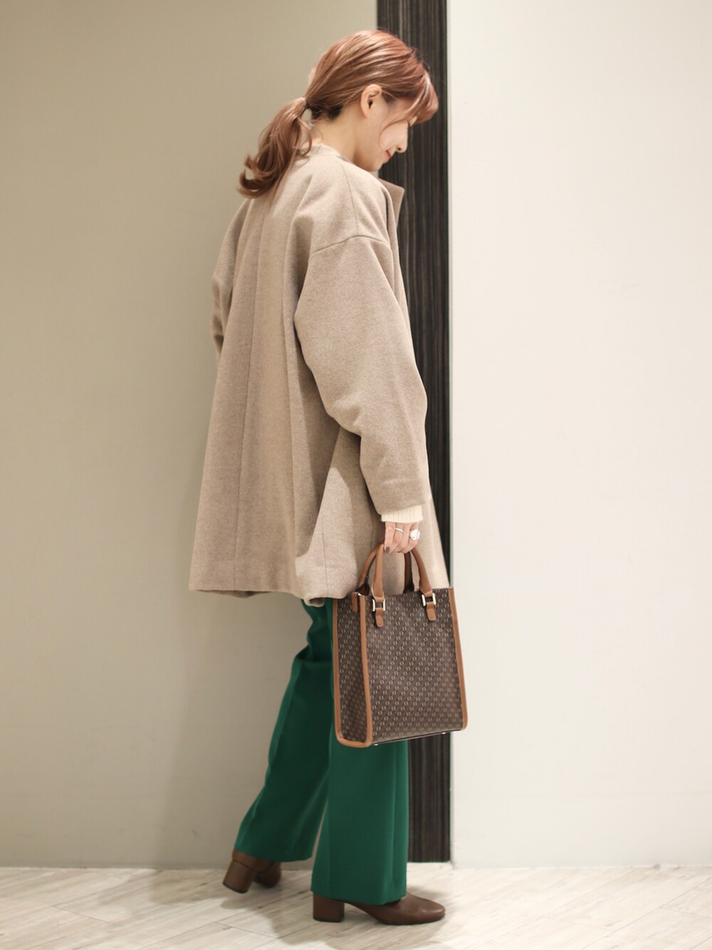 グリーン系のその他パンツ、ブラウン系のブーツ、ブラウン系のトートバッグを着用したレディースの冬コーディネートの3枚目の写真