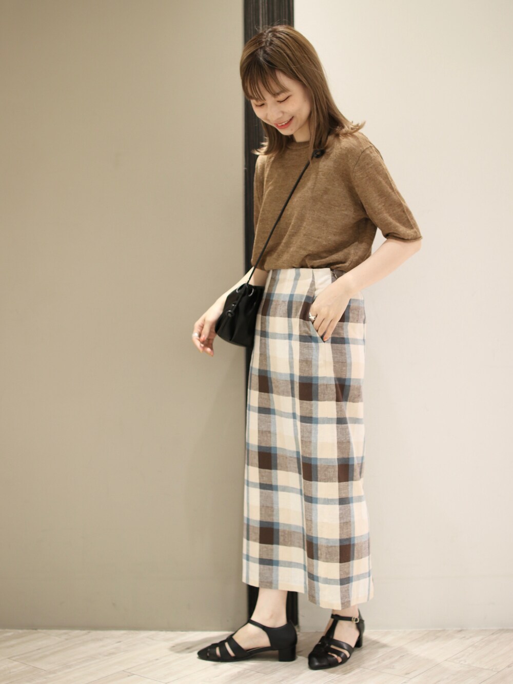 ブラック系のサンダル、ブラウン系のTシャツ/カットソー、ブルー系のスカートを着用したレディースの夏コーディネートの3枚目の写真