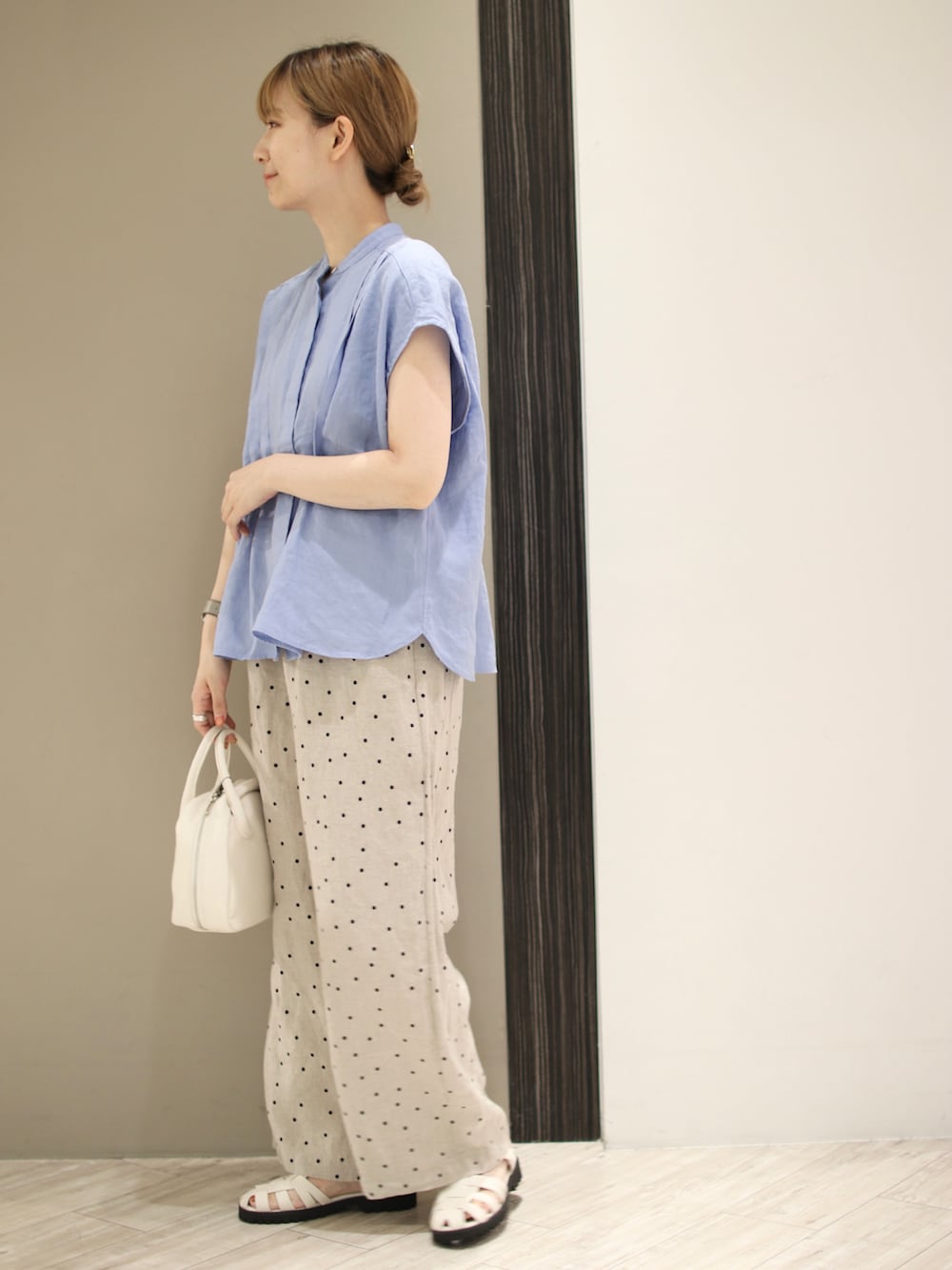ホワイト系のボストンバッグ、ベージュ系のその他パンツ、ブルー系のシャツ/ブラウスを着用したレディースの夏コーディネートの3枚目の写真