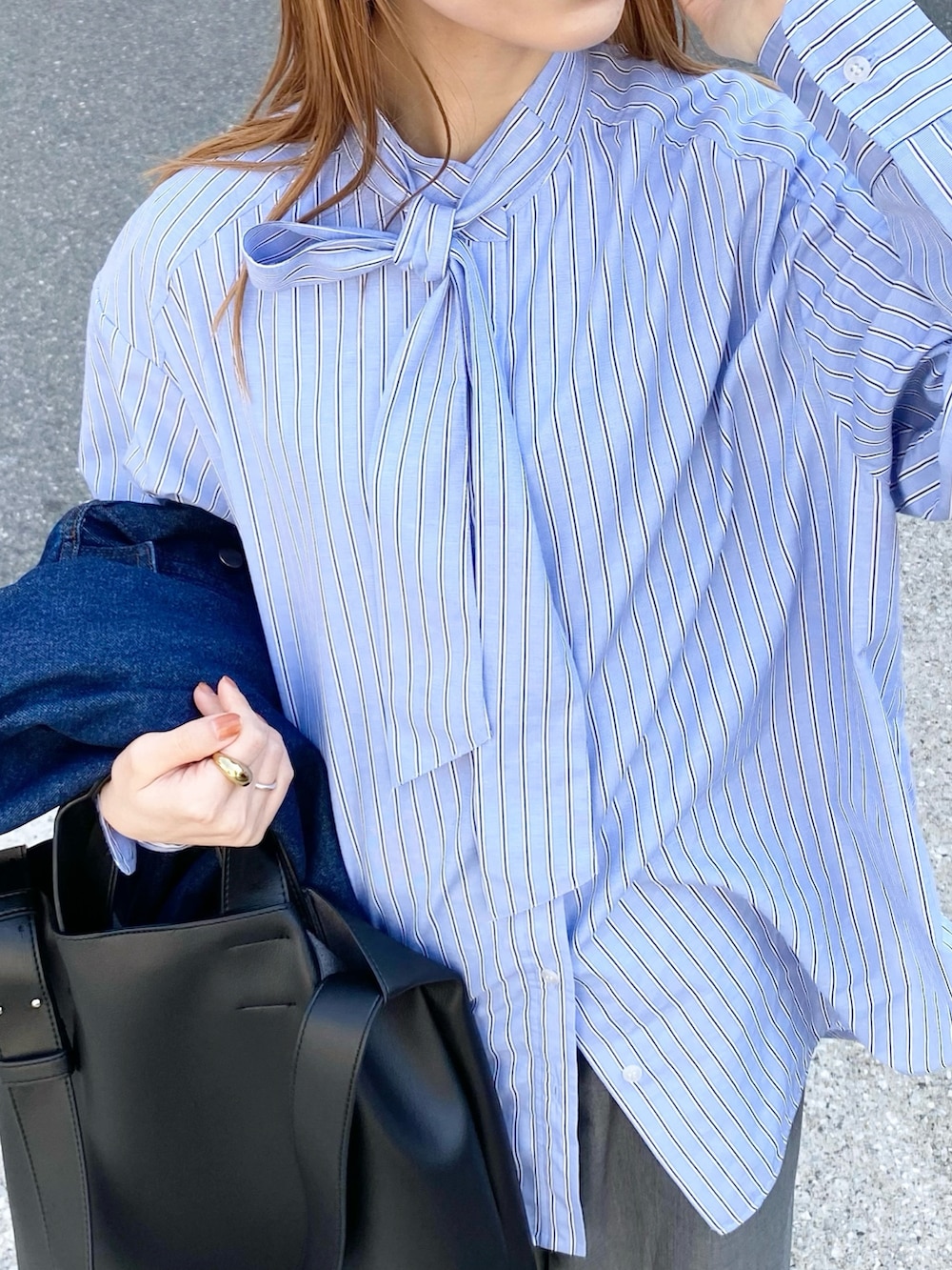 グレー系のパンツ、ブラック系のトートバッグ、ブルー系のシャツ/ブラウスを着用したレディースの春コーディネートの2枚目の写真