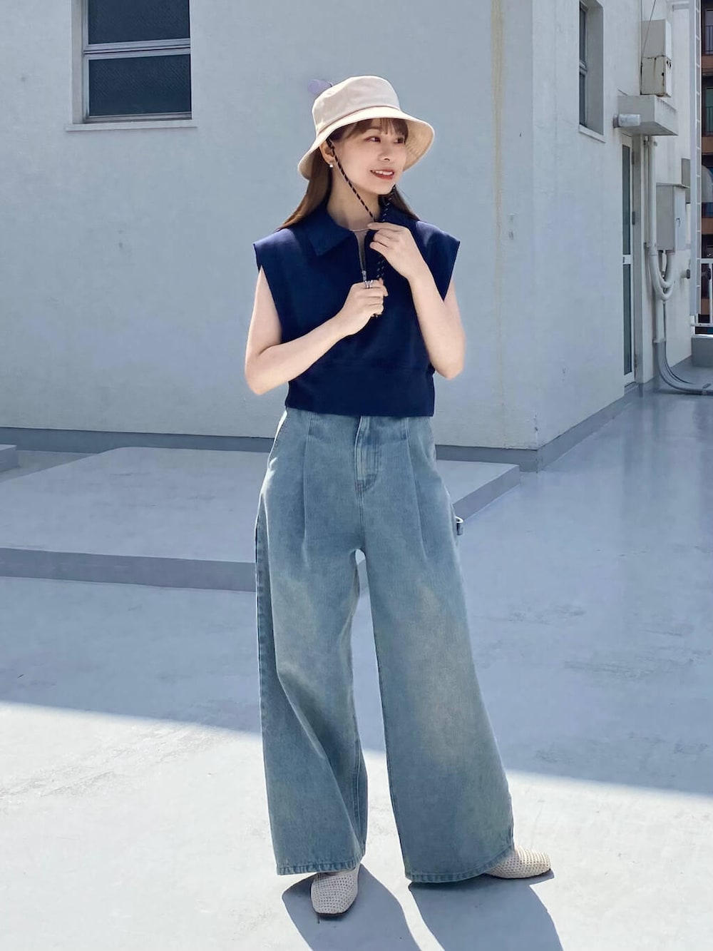 ブルー系のデニムパンツ、ホワイト系のバレエシューズ、ブルー系のスウェットを着用したレディースの春コーディネートの2枚目の写真