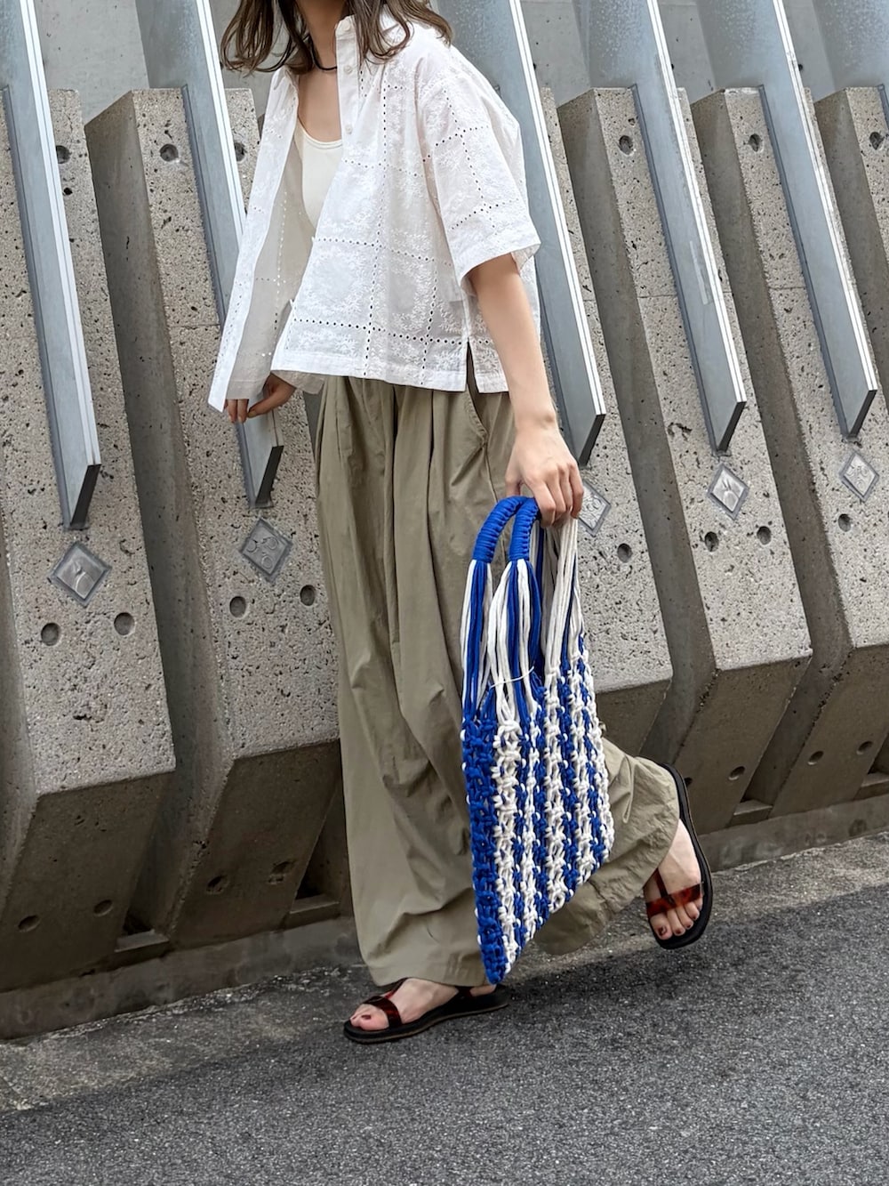 ベージュ系のその他パンツ、ブラック系のサンダル、ブルー系のハンドバッグを着用したレディースの秋コーディネートの4枚目の写真