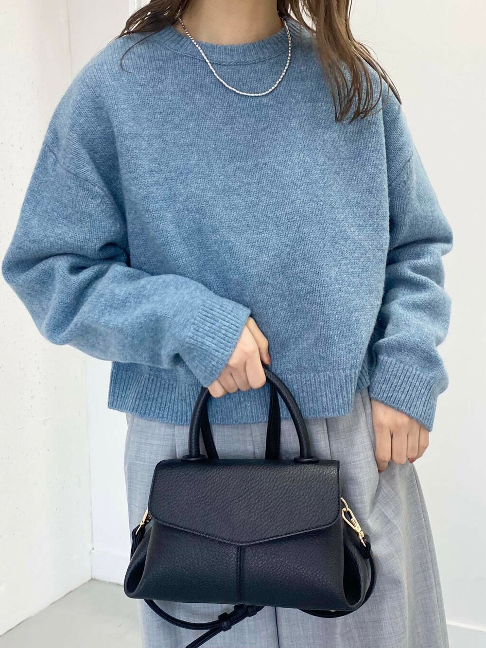 ブラック系のショルダーバッグ、グレー系のその他パンツ、ブラック系のブーツを着用したレディースの冬コーディネートの4枚目の写真