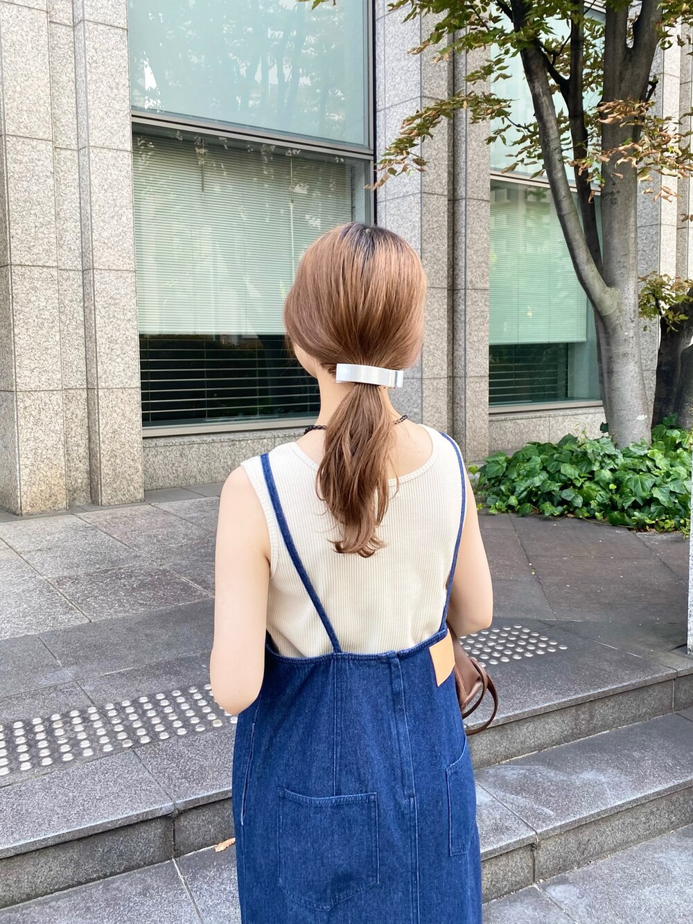 ブルー系のワンピース、ブラウン系のトートバッグ、ホワイト系のタンクトップを着用したレディースの秋コーディネートの2枚目の写真