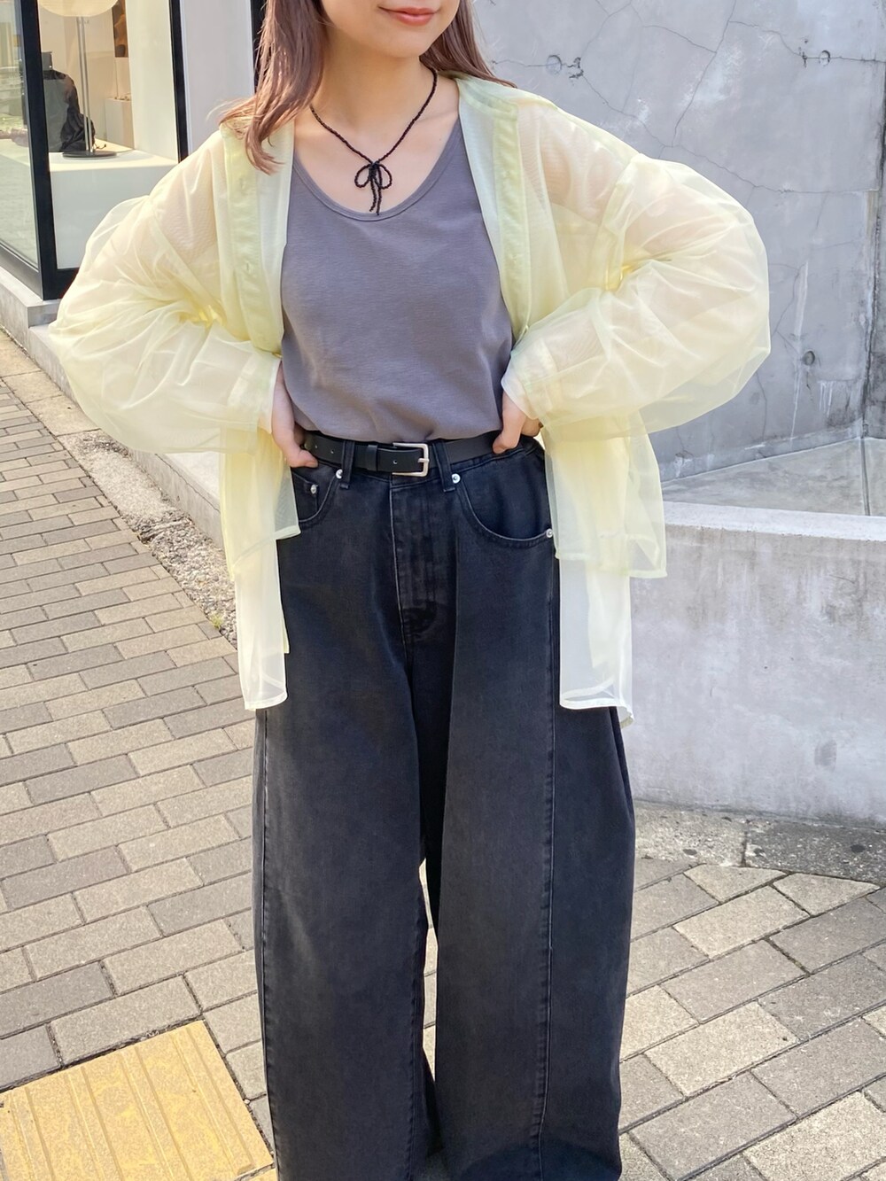 グレー系のタンクトップ、グリーン系のシャツ/ブラウス、ブラック系のデニムパンツを着用したレディースの夏コーディネートの4枚目の写真