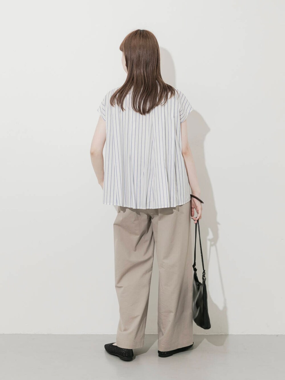 ベージュ系のその他パンツ、ブラック系のショルダーバッグ、ブラック系のバレエシューズを着用したレディースの夏コーディネートの3枚目の写真