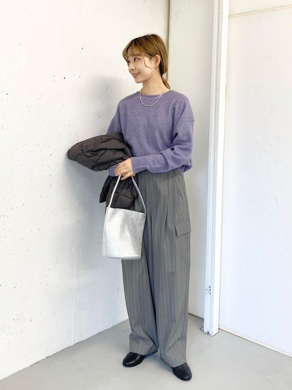 グレー系のその他パンツ、ブラック系のブーツ、シルバー系のハンドバッグを着用したレディースの冬コーディネートの5枚目の写真