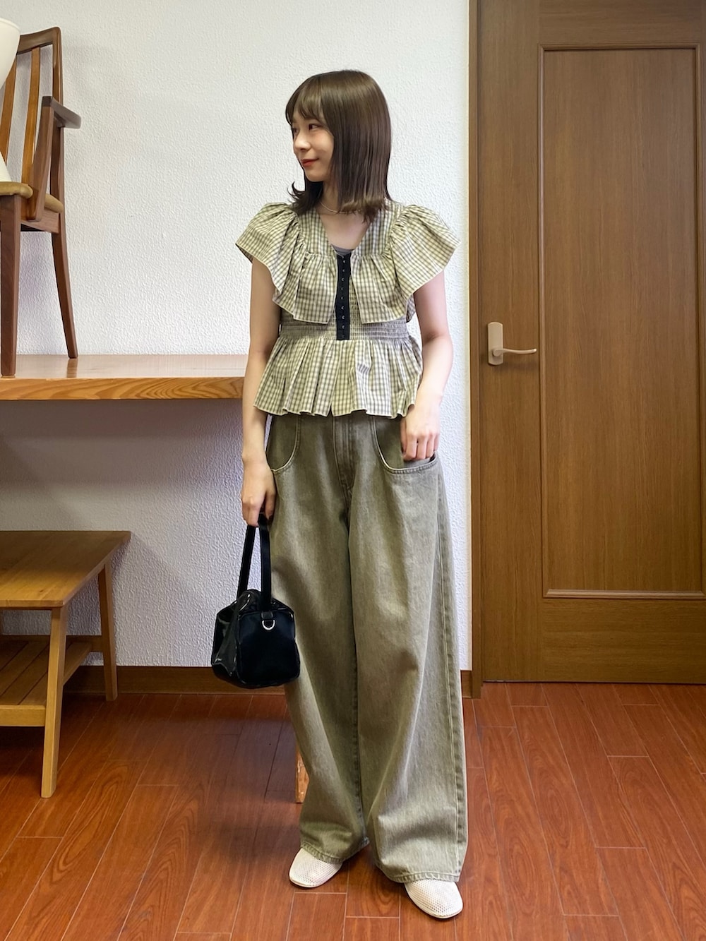 ブラック系のトートバッグ、ベージュ系のシャツ/ブラウス、ホワイト系のパンプスを着用したレディースの春コーディネートの2枚目の写真