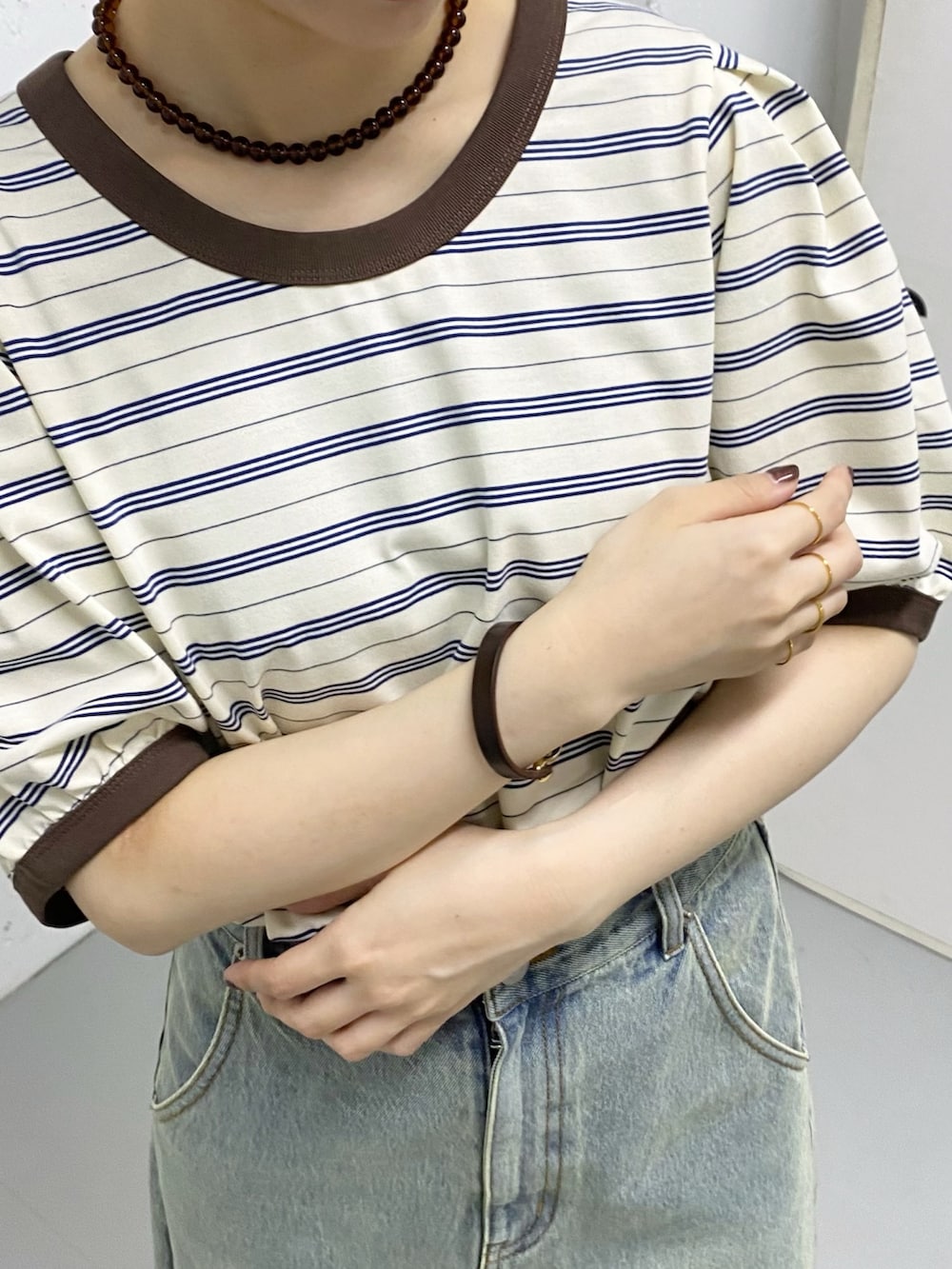 ブルー系のスカート、ホワイト系のTシャツ/カットソー、ゴールド系のリングを着用したレディースの春コーディネートの4枚目の写真