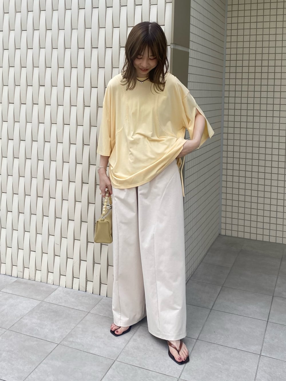 ブラウン系のサンダル、ベージュ系のショルダーバッグ、イエロー系のTシャツ/カットソーを着用したレディースの夏コーディネートの6枚目の写真