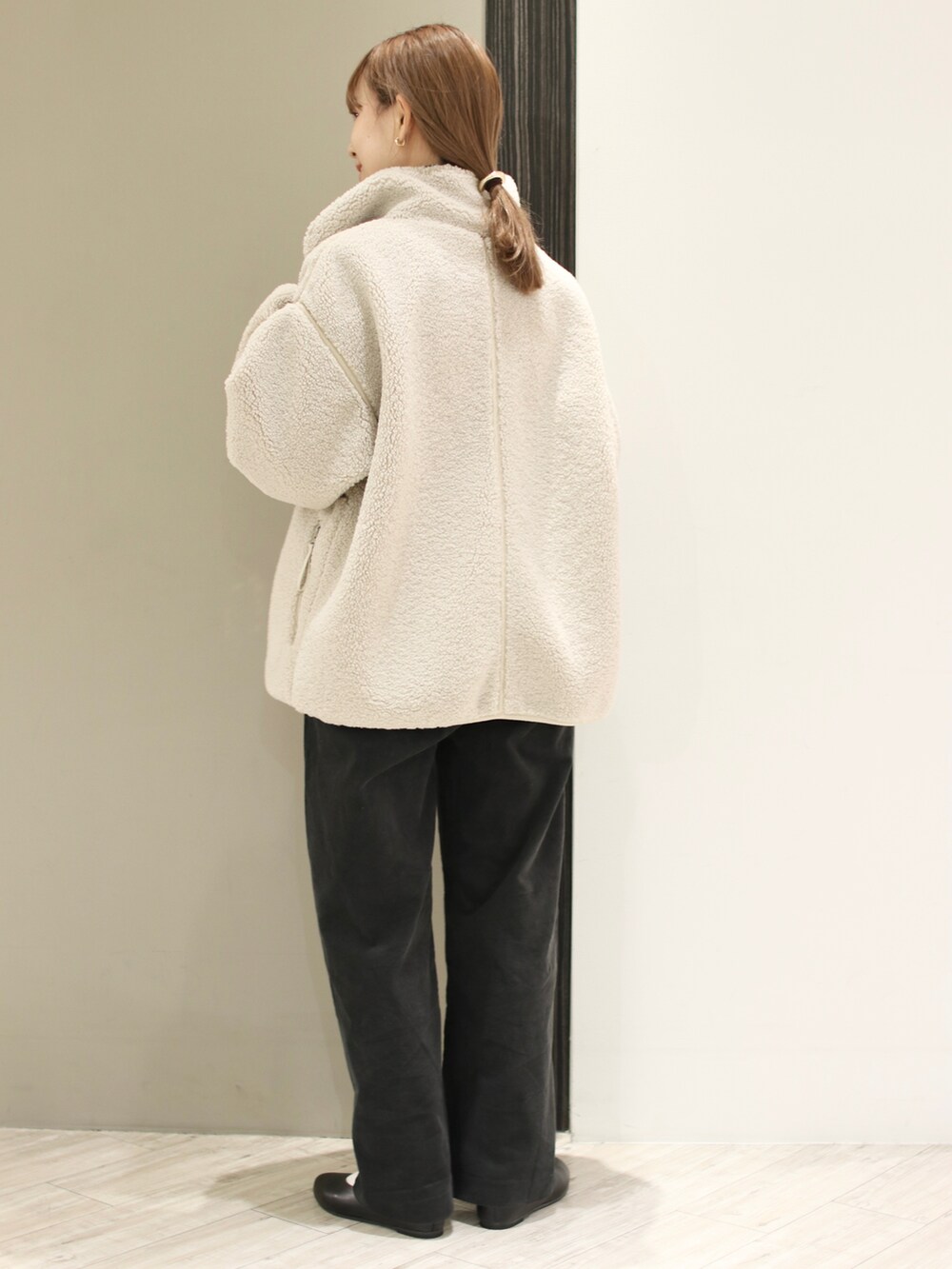 グレー系のその他パンツ、ブルー系のニット/セーター、ホワイト系のブルゾンを着用したレディースの冬コーディネートの4枚目の写真