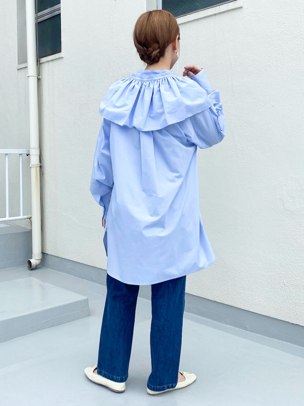 ブルー系のデニムパンツ、パープル系のワンピース、ホワイト系のバレエシューズを着用したレディースの秋コーディネートの5枚目の写真