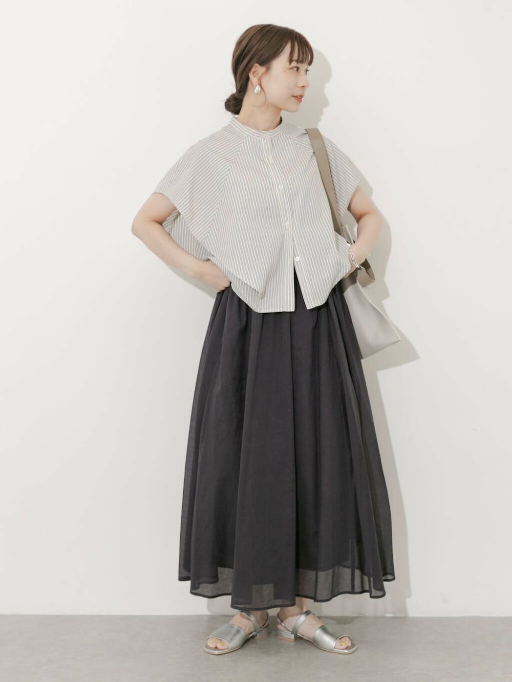 グレー系のスカート、ホワイト系のシャツ/ブラウス、シルバー系のサンダルを着用したレディースの夏コーディネートの7枚目の写真
