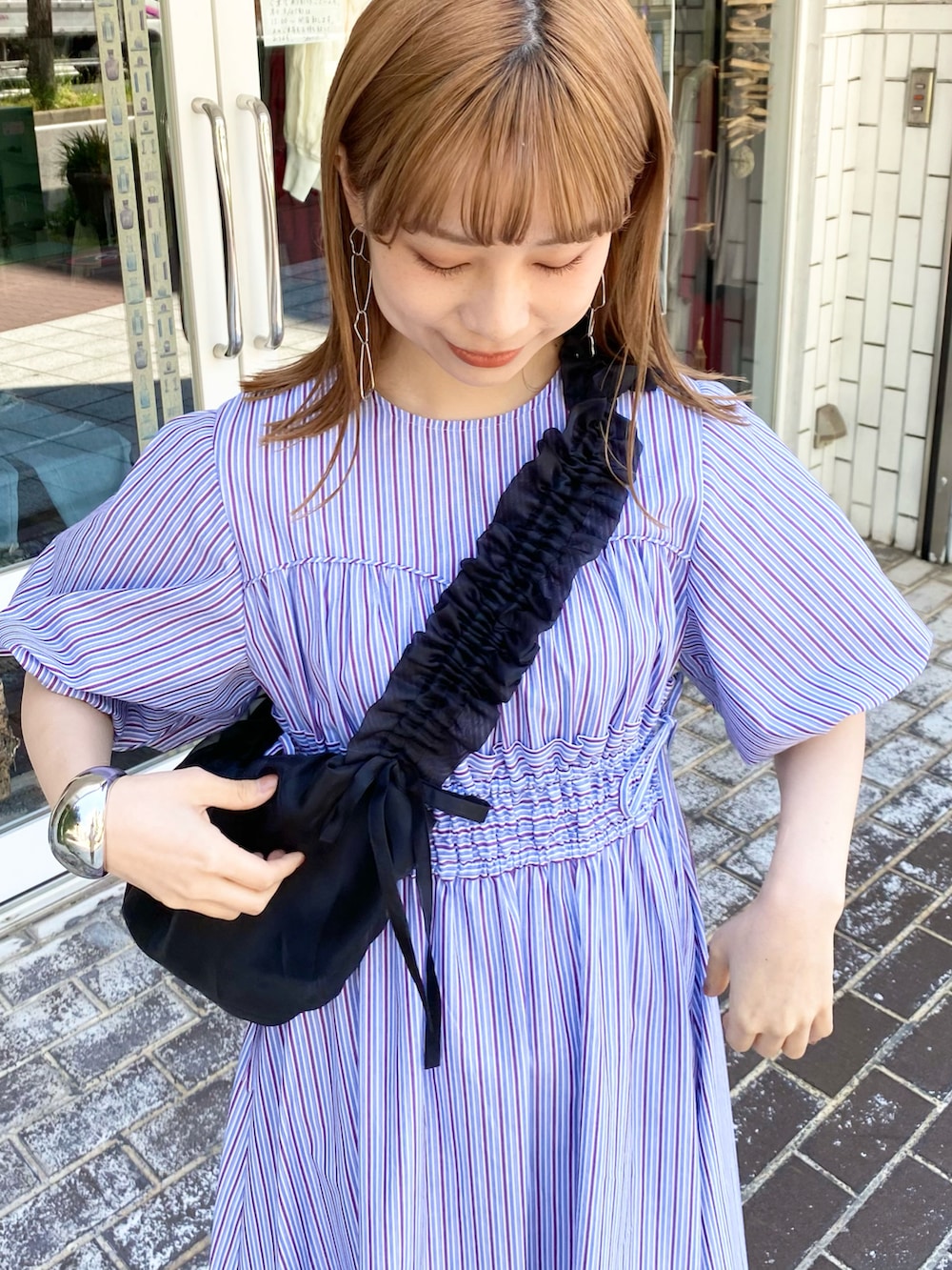 ブラック系のショルダーバッグ、パープル系のワンピース、シルバー系のサンダルを着用したレディースの夏コーディネートの4枚目の写真