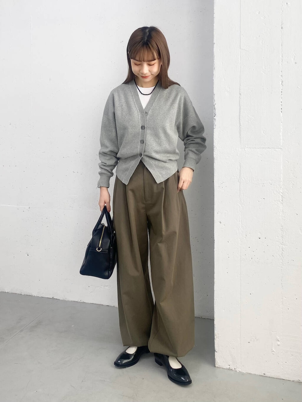 ブラック系のボストンバッグ、ブラック系のローファー、グレー系のカーディガン/ボレロを着用したレディースの春コーディネートの3枚目の写真