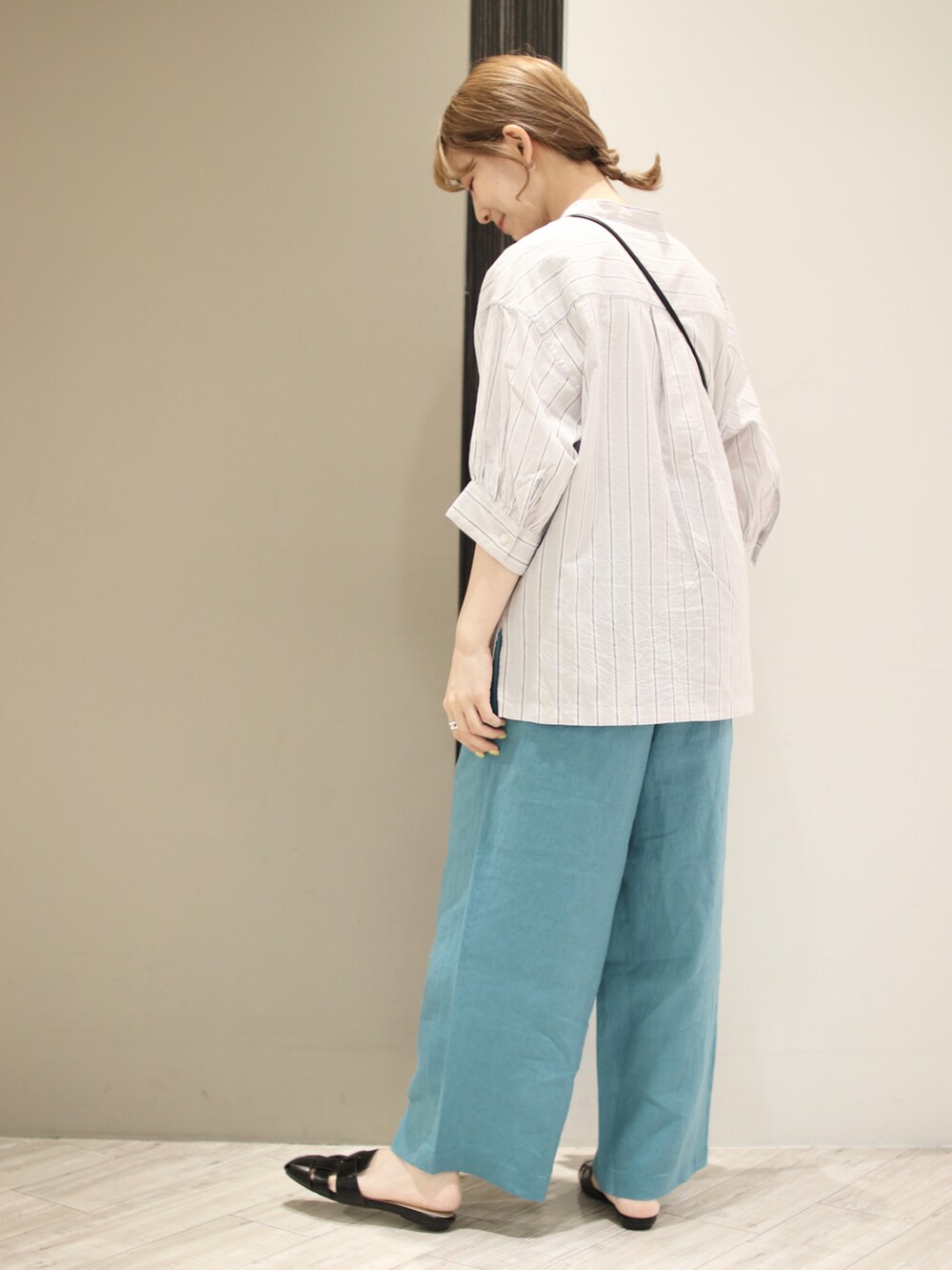 ブラック系のサンダル、ブルー系のその他パンツ、ブラック系のショルダーバッグを着用したレディースの夏コーディネートの4枚目の写真