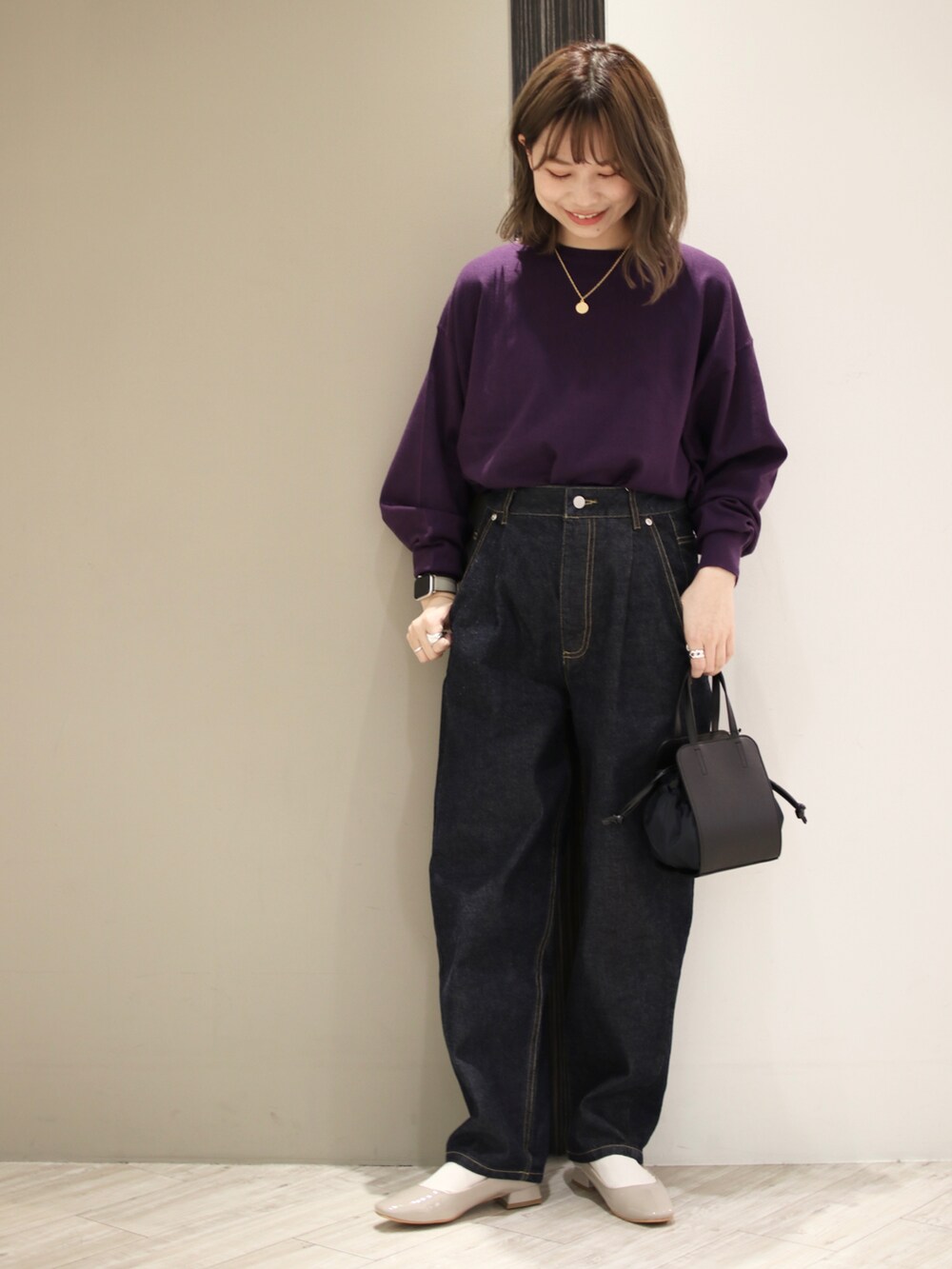 ブルー系のデニムパンツ、ブラック系のショルダーバッグ、パープル系のニット/セーターを着用したレディースの冬コーディネートの2枚目の写真