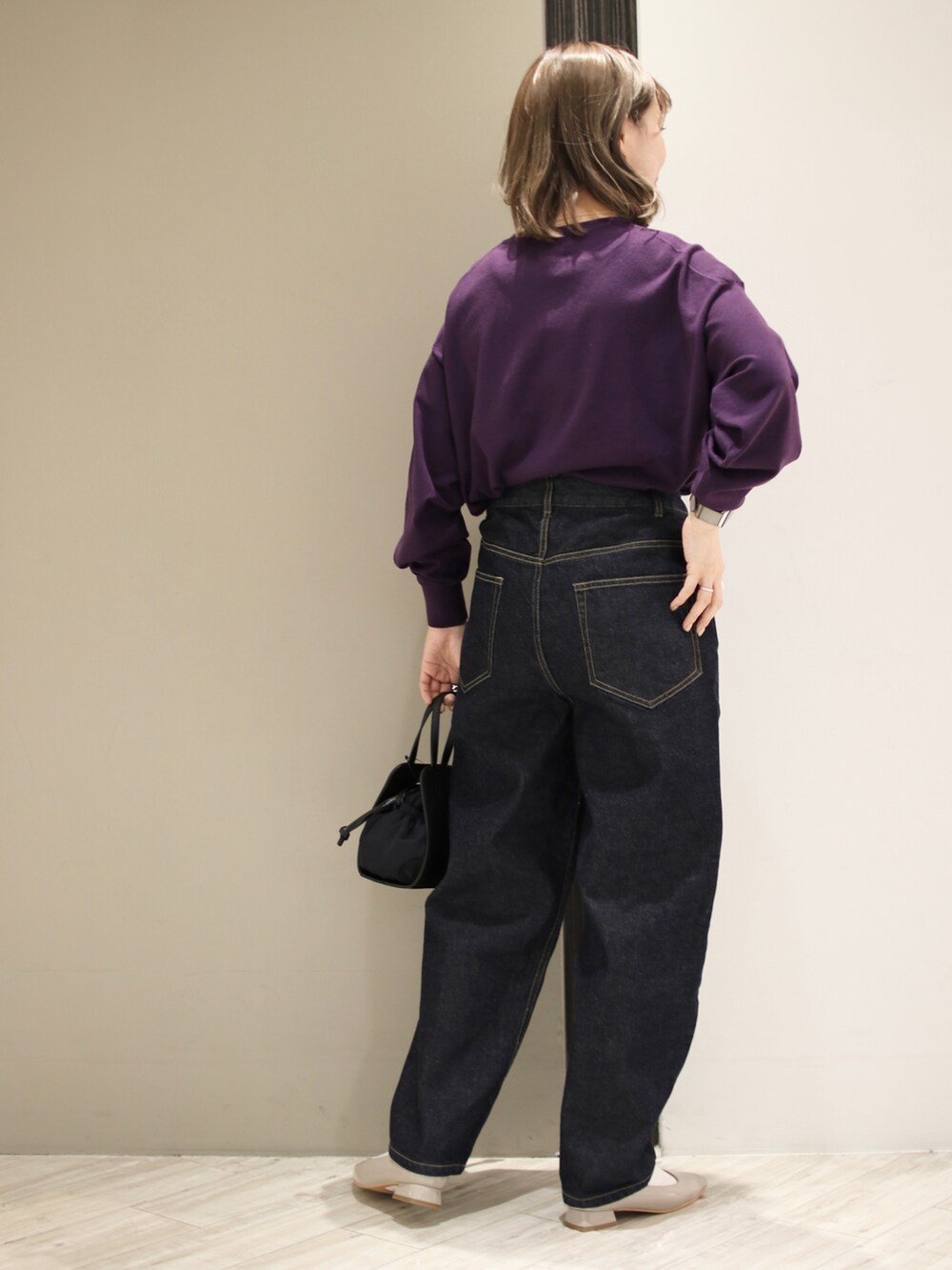 ブルー系のデニムパンツ、ブラック系のショルダーバッグ、パープル系のニット/セーターを着用したレディースの冬コーディネートの4枚目の写真