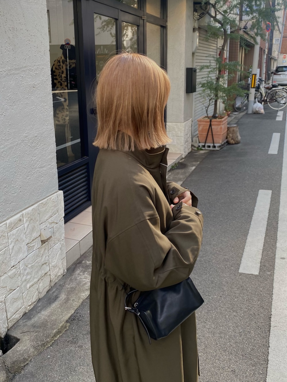 グリーン系のその他アウター、ホワイト系のその他パンツ、ブラック系のパンプスを着用したレディースの冬コーディネートの5枚目の写真