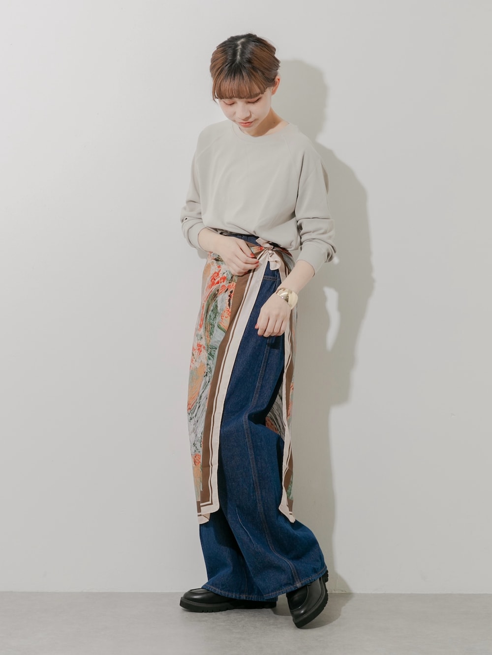 ブラック系のローファー、ベージュ系のTシャツ/カットソー、ブルー系のデニムパンツを着用したレディースの秋コーディネートの4枚目の写真