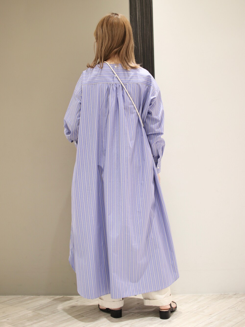 ブルー系のワンピース、ベージュ系のショルダーバッグ、ブラック系のサンダルを着用したレディースの春コーディネートの2枚目の写真