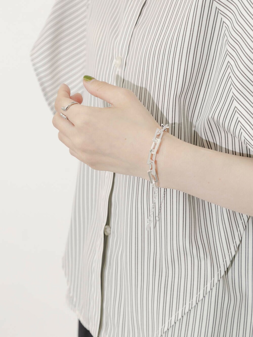 グレー系のスカート、ホワイト系のシャツ/ブラウス、シルバー系のサンダルを着用したレディースの夏コーディネートの6枚目の写真