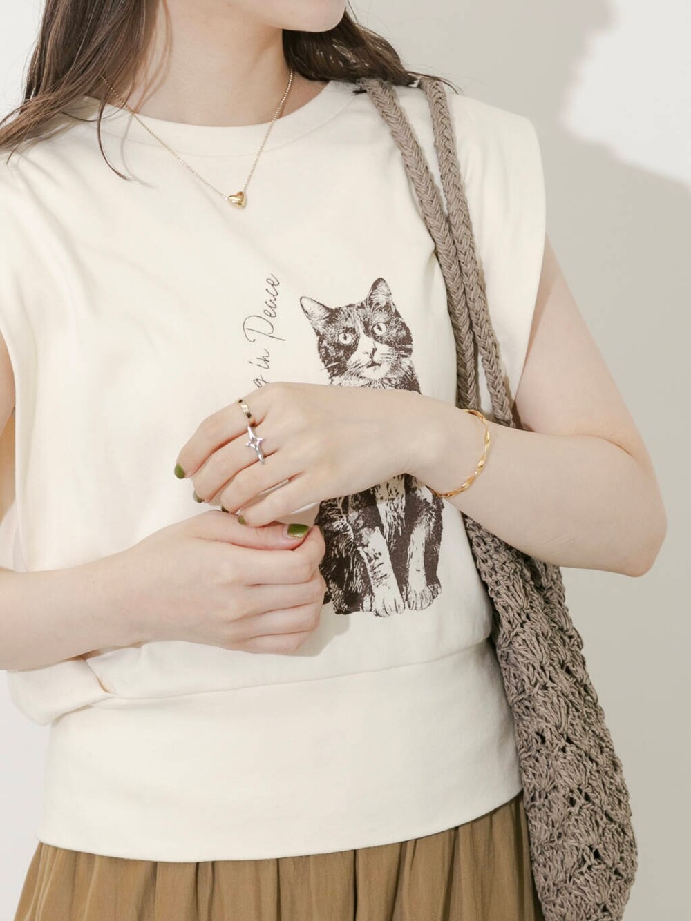 グレー系のトートバッグ、イエロー系のTシャツ/カットソー、ブラウン系のサンダルを着用したレディースの夏コーディネートの3枚目の写真