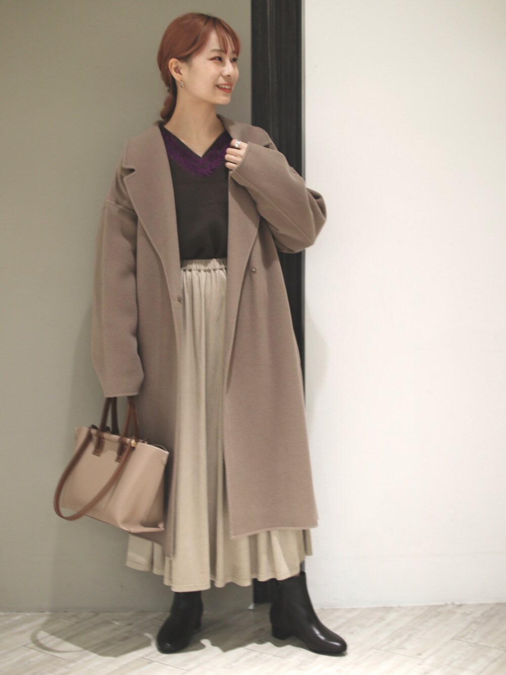 ブラウン系のトートバッグ、ブラウン系のチェスターコート、ブラウン系のニット/セーターを着用したレディースの冬コーディネートの4枚目の写真