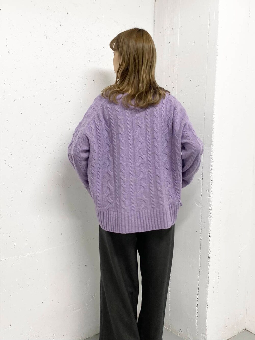 パープル系のニット/セーター、グレー系のその他パンツ、ブラック系のブーツを着用したレディースの秋コーディネートの6枚目の写真