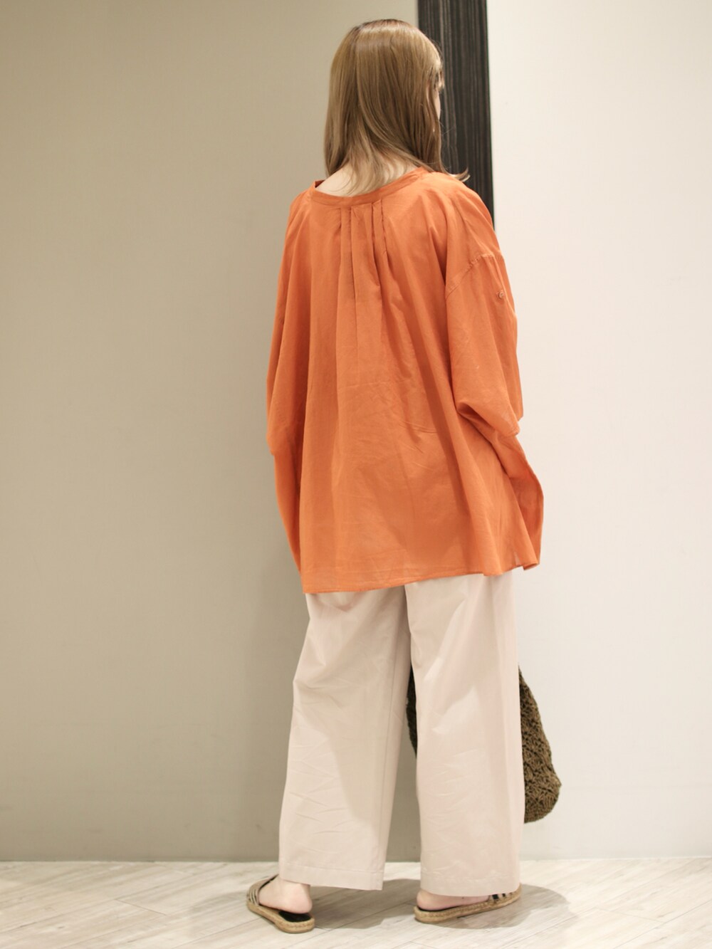 オレンジ系のシャツ/ブラウス、ベージュ系のその他パンツ、グリーン系のトートバッグを着用したレディースの夏コーディネートの3枚目の写真