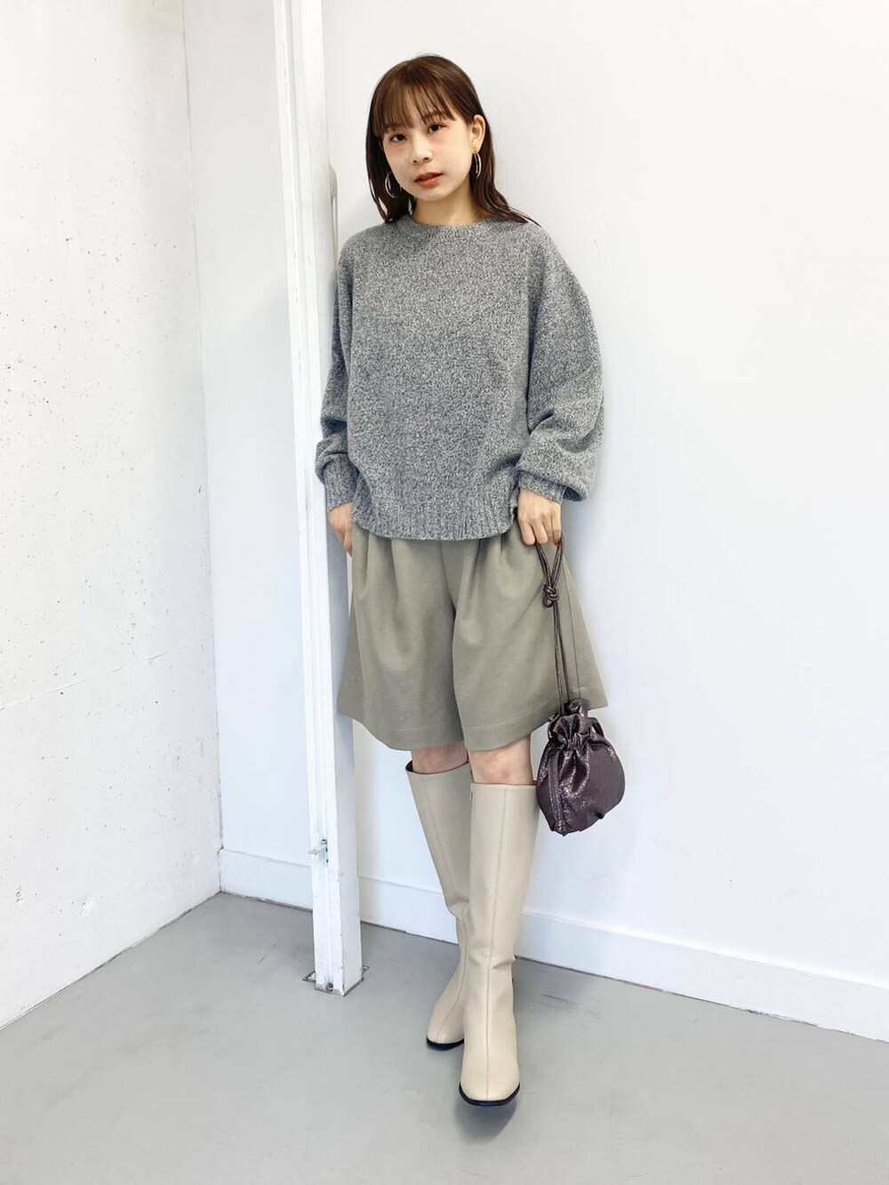 グレー系のニット/セーター、ベージュ系のその他パンツ、ホワイト系のブーツを着用したレディースの冬コーディネートの3枚目の写真