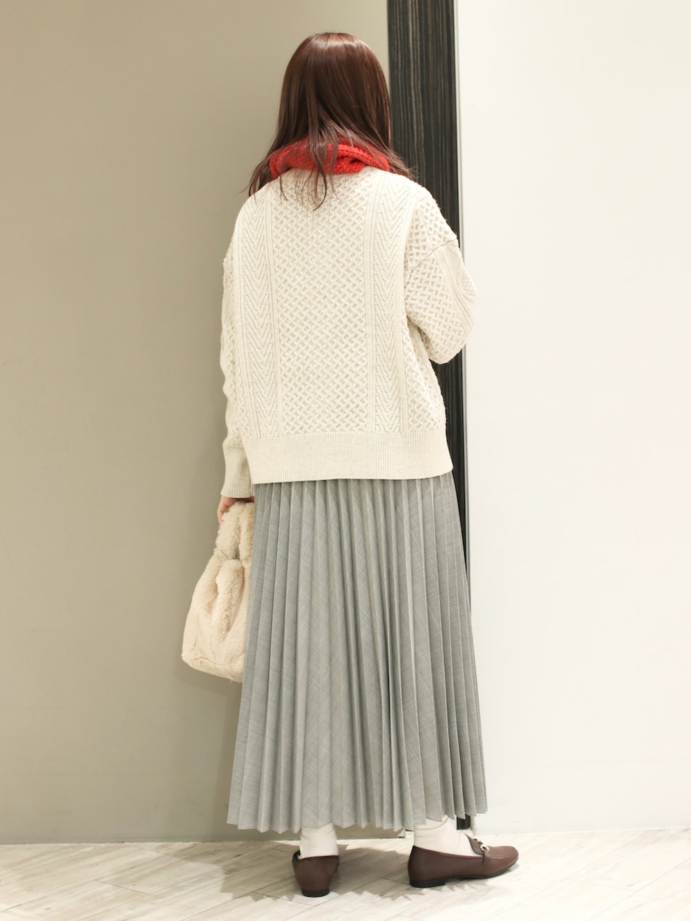 ホワイト系のカーディガン/ボレロ、ホワイト系のハンドバッグ、ブラウン系のローファーを着用したレディースの冬コーディネートの4枚目の写真