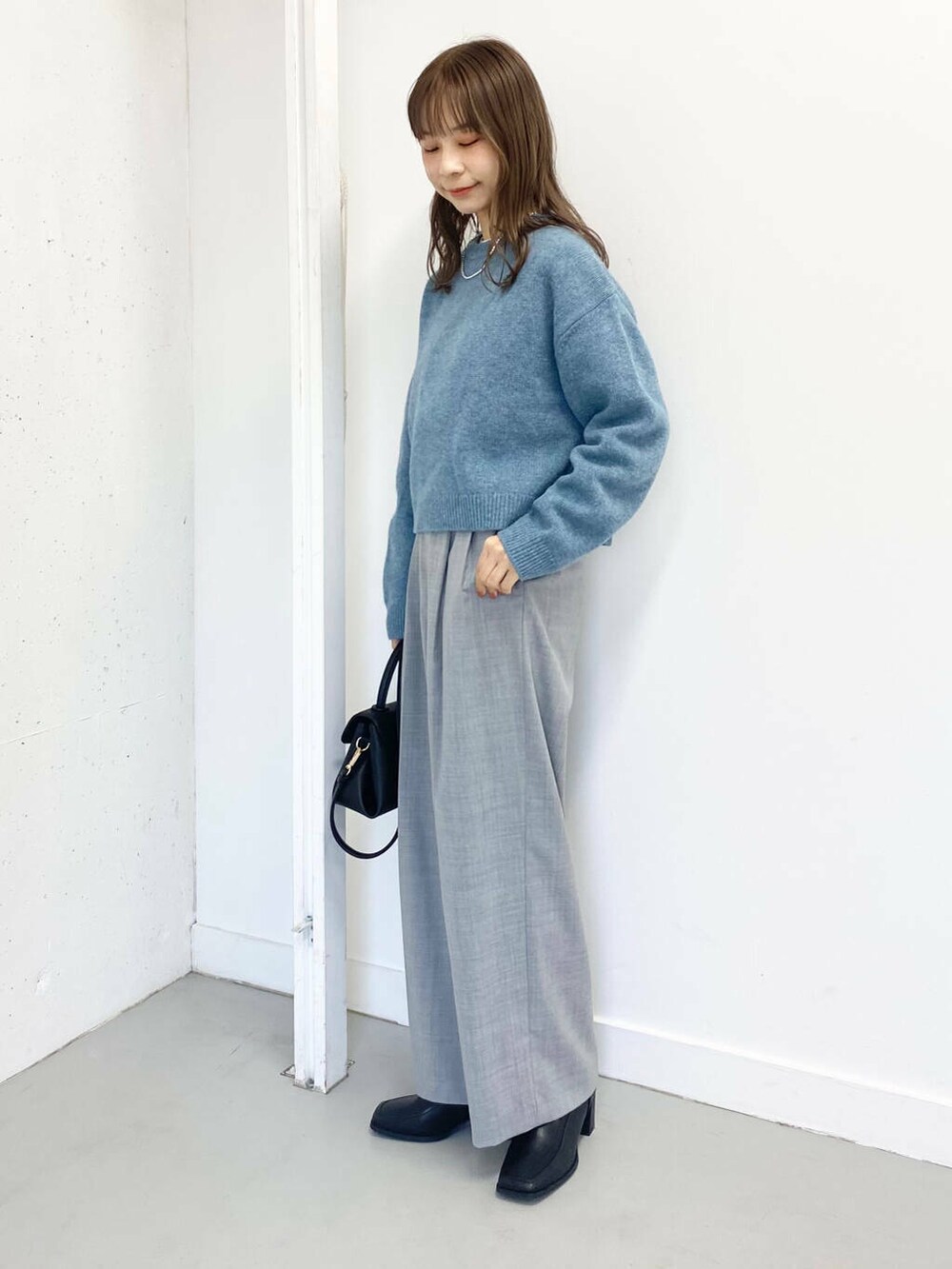 ブラック系のショルダーバッグ、グレー系のその他パンツ、ブラック系のブーツを着用したレディースの冬コーディネートの6枚目の写真