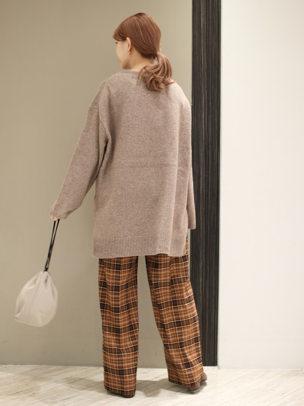 ブラウン系のニット/セーター、ブラウン系のその他パンツ、ベージュ系のショルダーバッグを着用したレディースの秋コーディネートの3枚目の写真