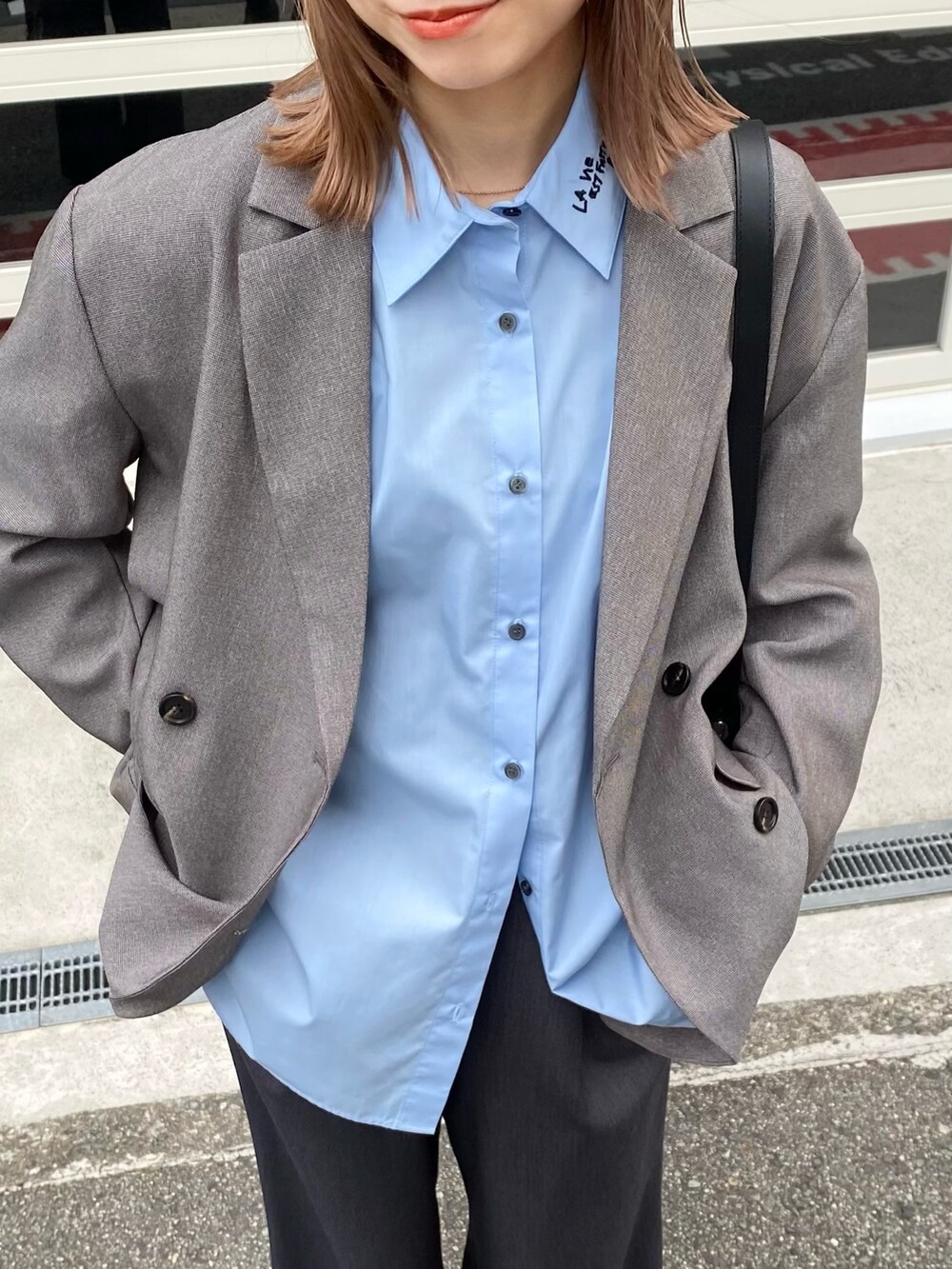 ブラック系のショルダーバッグ、グレー系のその他アウター、ブルー系のシャツ/ブラウスを着用したレディースの秋コーディネートの3枚目の写真