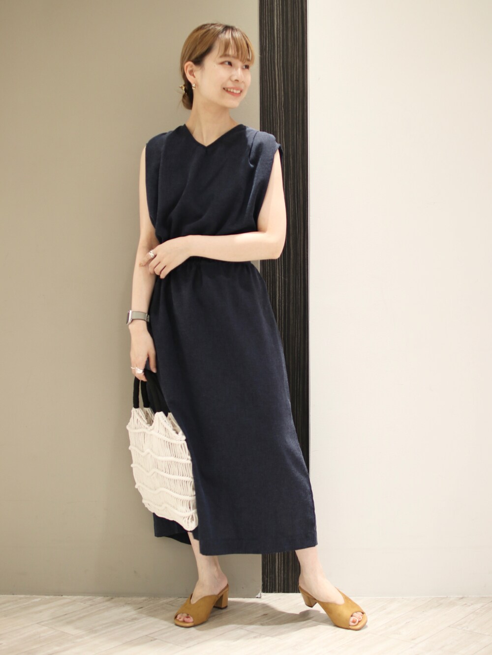 ホワイト系のハンドバッグ、イエロー系のサンダル、ブルー系のワンピースを着用したレディースの夏コーディネートの2枚目の写真