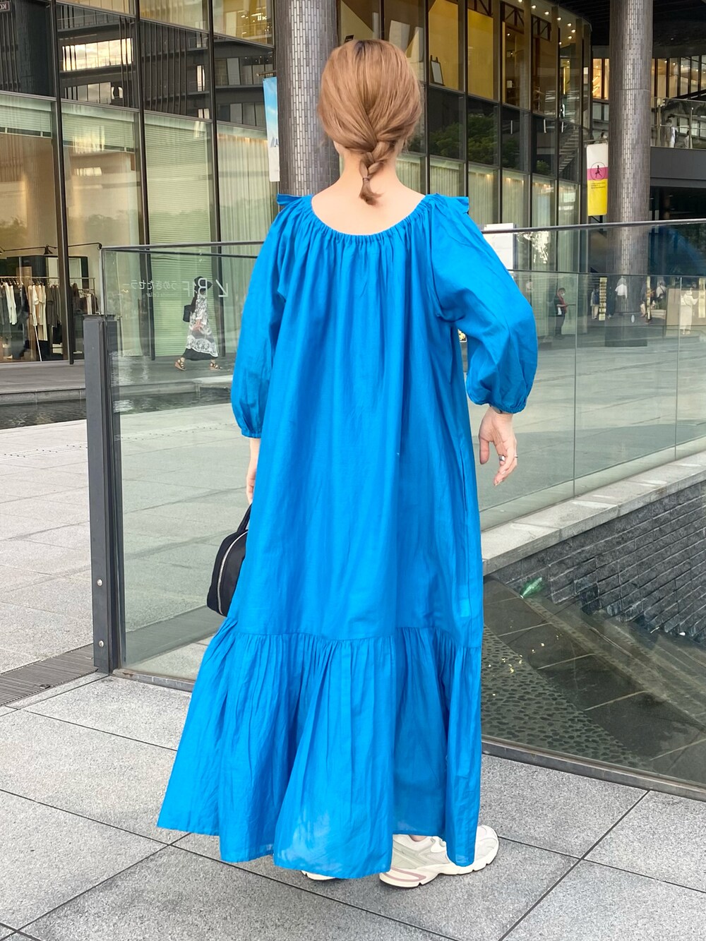 ブルー系のワンピース/ドレス、ブラック系のボストンバッグ、ホワイト系のスニーカーを着用したレディースの夏コーディネートの2枚目の写真