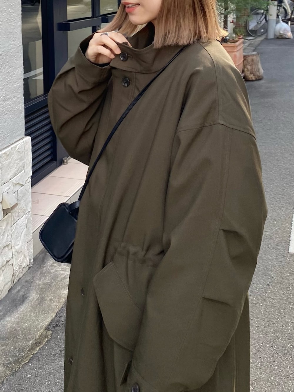 グリーン系のその他アウター、ホワイト系のその他パンツ、ブラック系のパンプスを着用したレディースの冬コーディネートの3枚目の写真