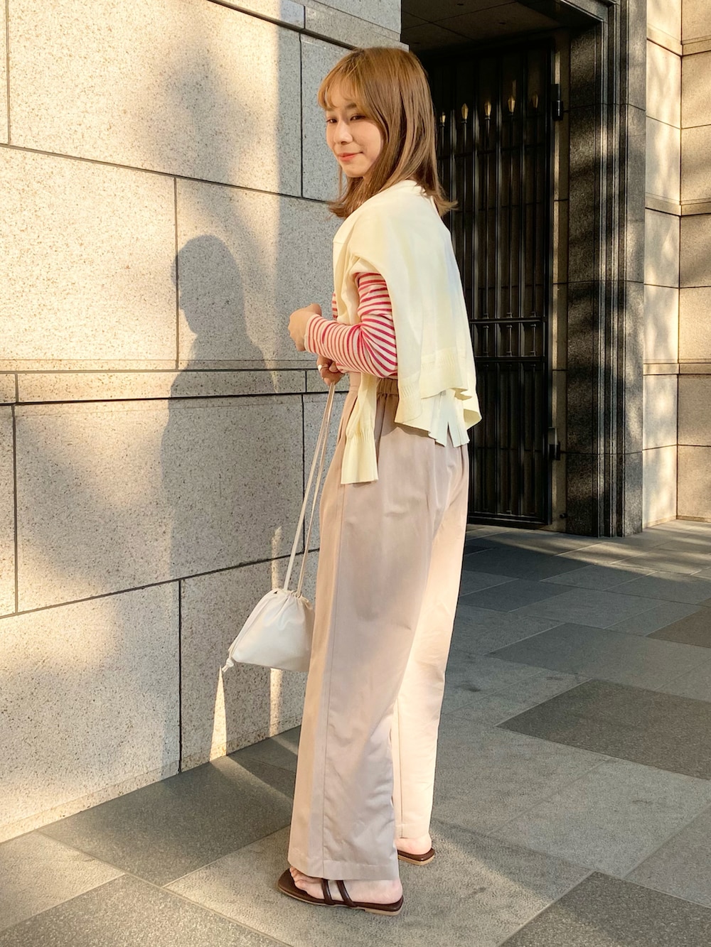 ピンク系のTシャツ/カットソー、ホワイト系のカーディガン/ボレロ、ホワイト系のショルダーバッグを着用したレディースの夏コーディネートの2枚目の写真