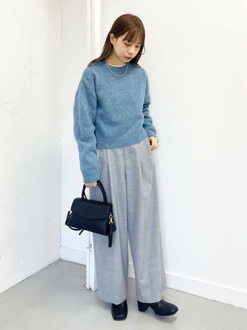 ブラック系のショルダーバッグ、グレー系のその他パンツ、ブラック系のブーツを着用したレディースの冬コーディネートの7枚目の写真