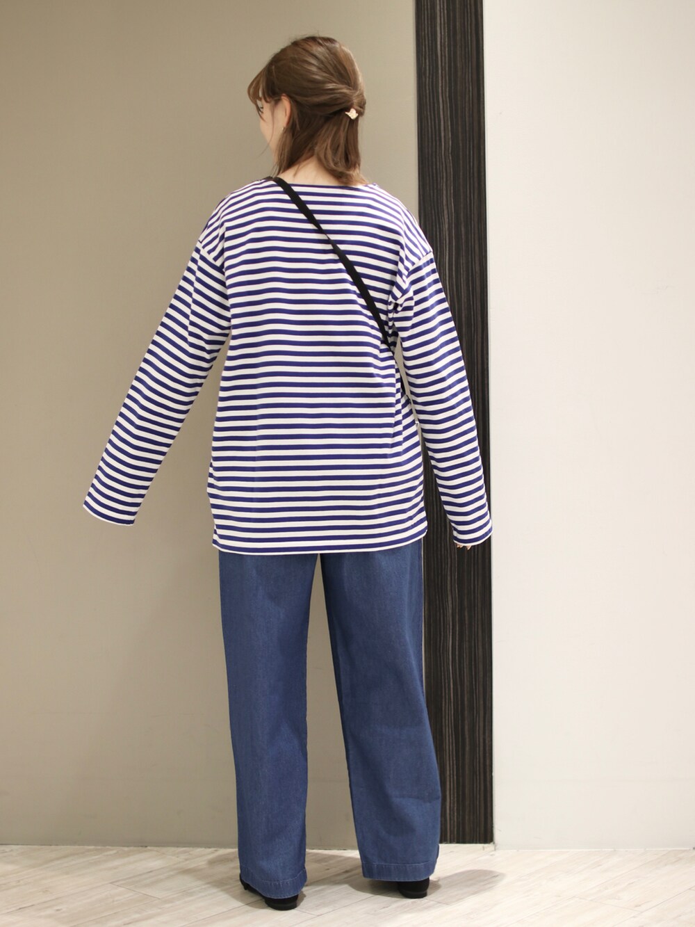 ブルー系のデニムパンツ、ブルー系のTシャツ/カットソー、ブラック系のバレエシューズを着用したレディースの冬コーディネートの5枚目の写真