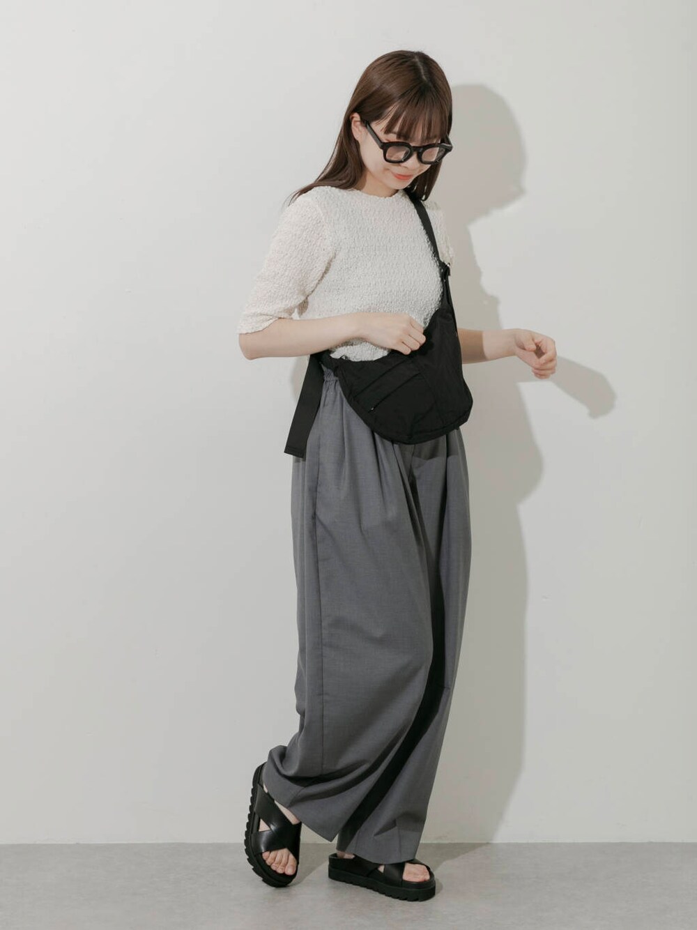 グレー系のその他パンツ、ホワイト系のTシャツ/カットソー、ブラック系のサンダルを着用したレディースの春コーディネートの5枚目の写真