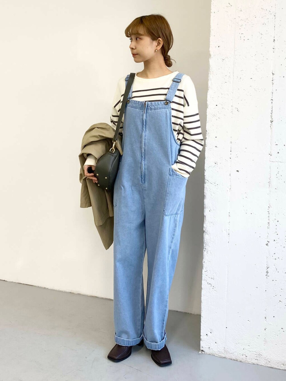 グリーン系のショルダーバッグ、ブラック系のブーツ、その他のニット/セーターを着用したレディースの冬コーディネートの6枚目の写真