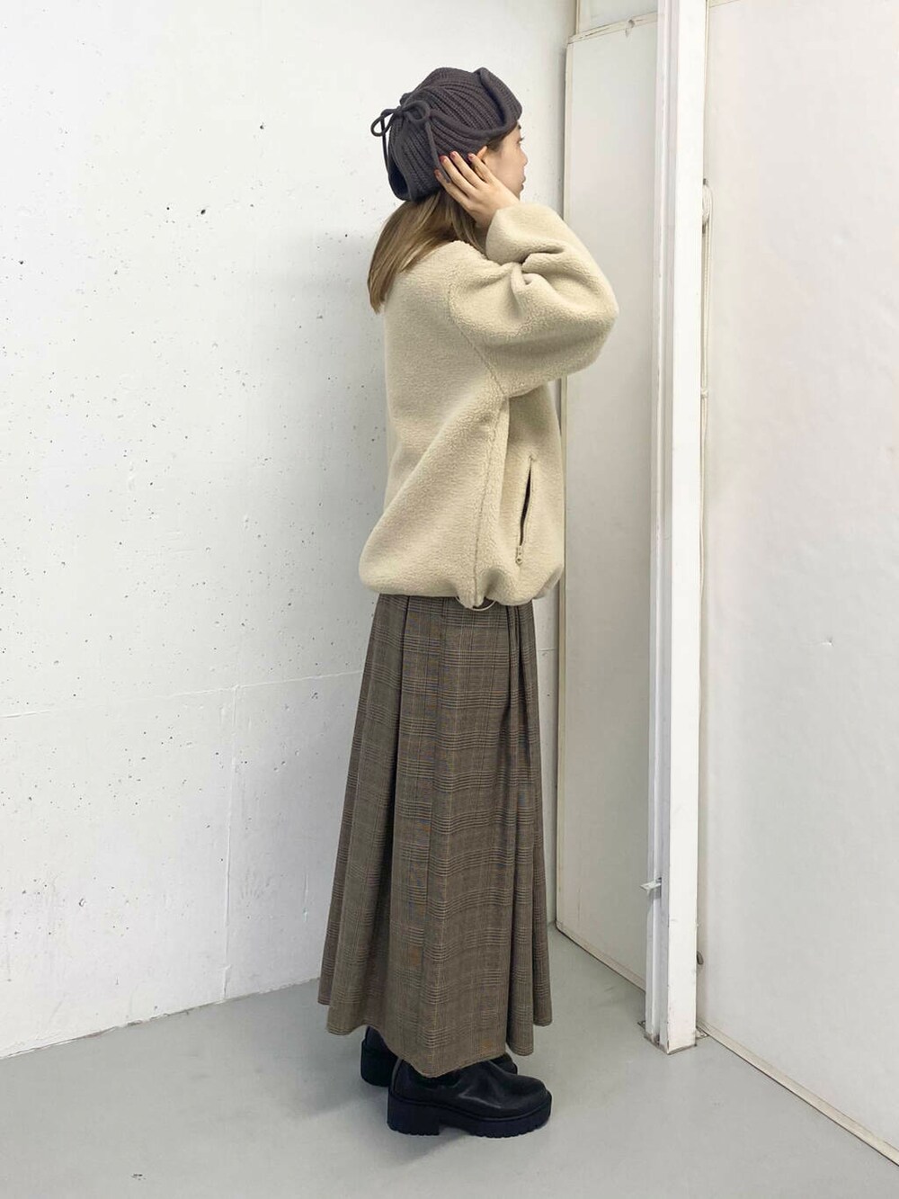 ブラック系のブーツ、その他のスカート、ホワイト系のブルゾンを着用したレディースの秋コーディネートの3枚目の写真