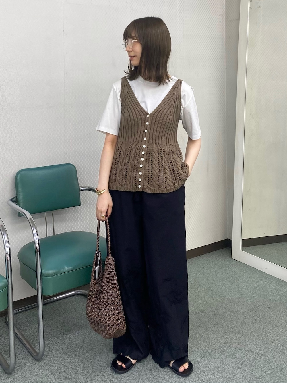 ベージュ系のベスト、ホワイト系のTシャツ/カットソー、ブラック系のその他パンツを着用したレディースの春コーディネートの2枚目の写真
