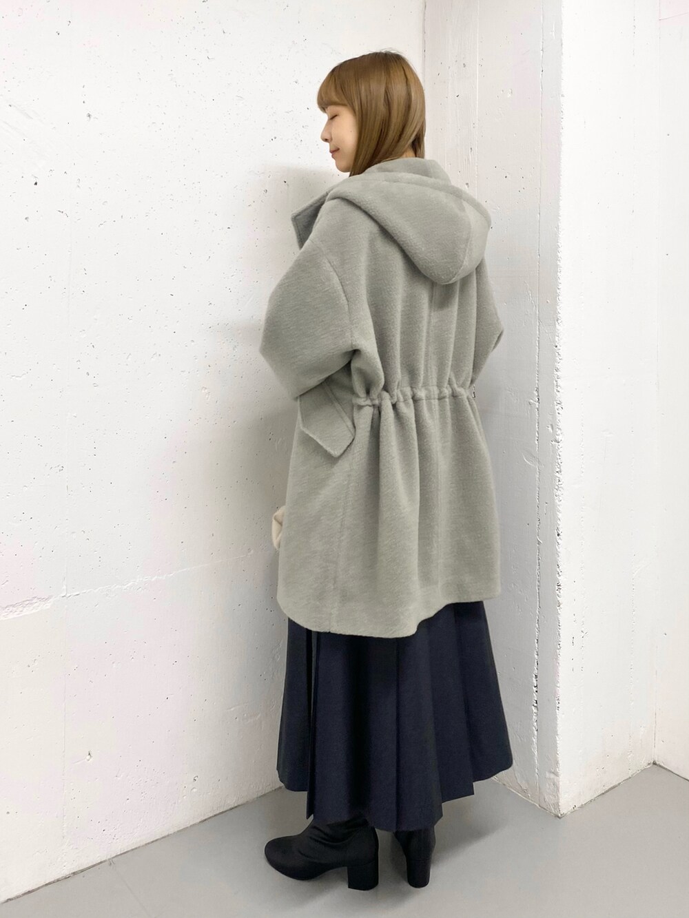 グリーン系のその他アウター、ホワイト系のニット/セーター、ブラック系のブーツを着用したレディースの冬コーディネートの4枚目の写真