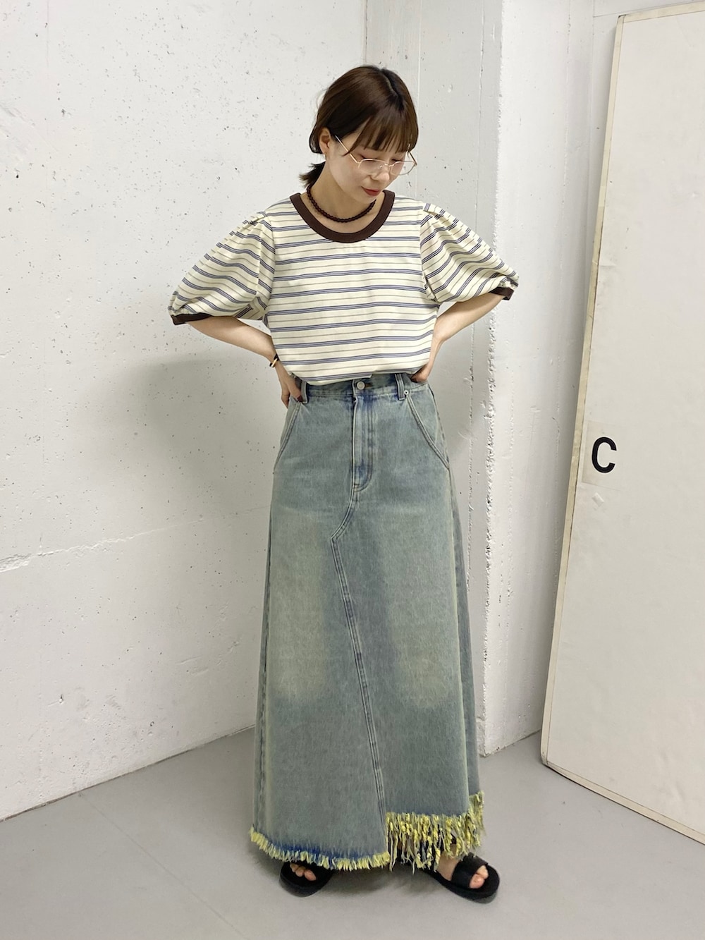 ブルー系のスカート、ホワイト系のTシャツ/カットソー、ゴールド系のリングを着用したレディースの春コーディネートの3枚目の写真