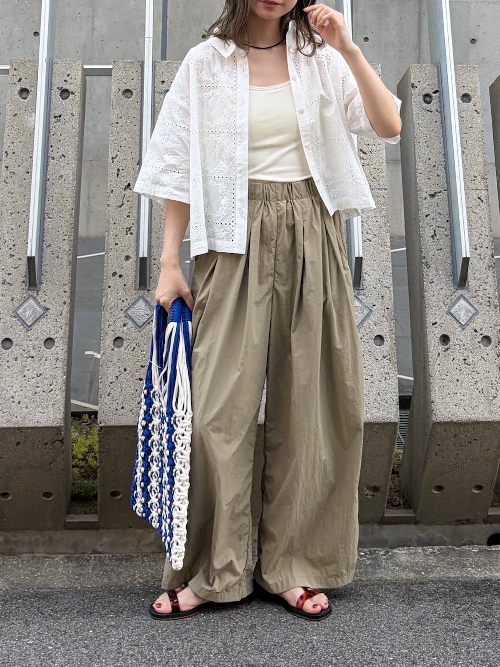 ベージュ系のその他パンツ、ブラック系のサンダル、ブルー系のハンドバッグを着用したレディースの秋コーディネートの3枚目の写真