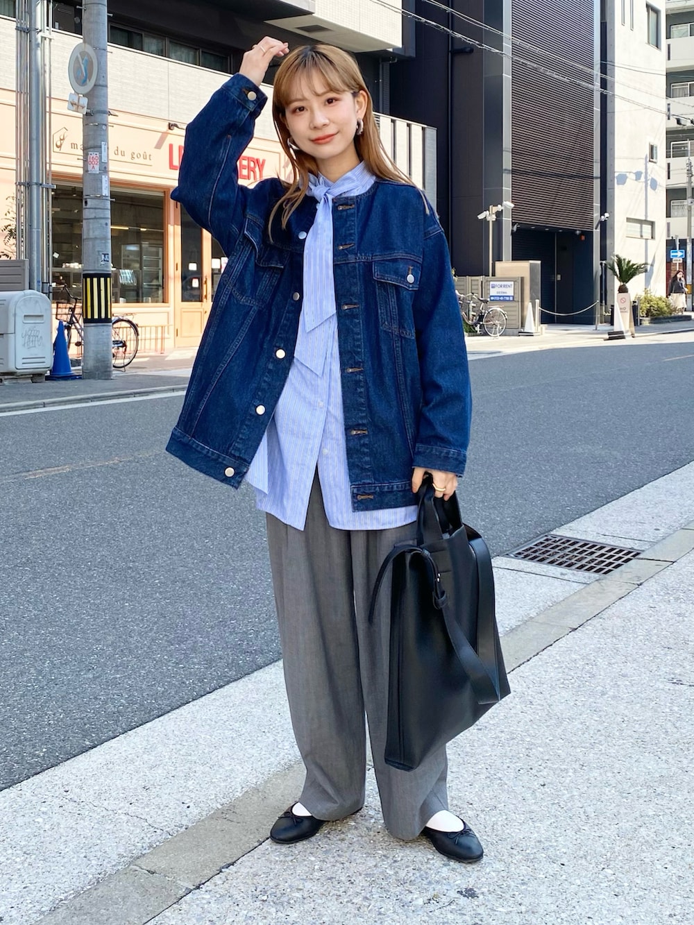 グレー系のパンツ、ブラック系のトートバッグ、ブルー系のシャツ/ブラウスを着用したレディースの春コーディネートの3枚目の写真