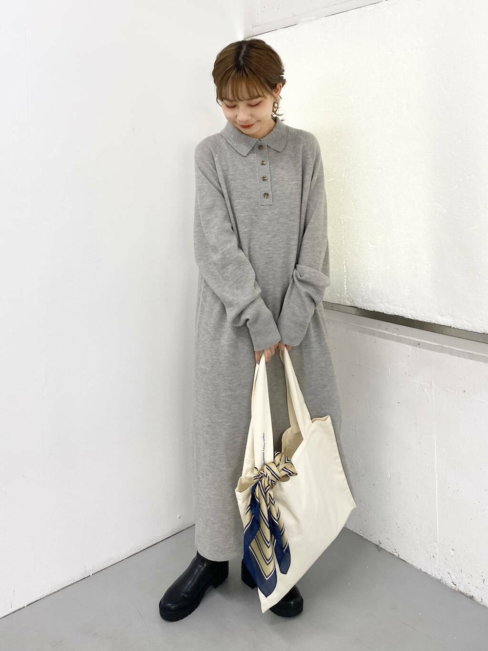 ブラック系のブーツ、ホワイト系のトートバッグ、グレー系のワンピースを着用したレディースの秋コーディネートの5枚目の写真